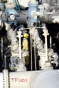 An iraqi techniqian inspects oil pipes at the al-Bakr port in the southern Iraqi city of Basra