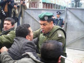 Israeli security forces disperse a crowd of Palestinians at a checkpoint in Hebron