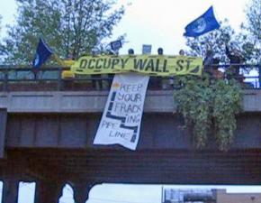 Occupy Earth Day demonstrators hold a banner drop from the High Line park in New York City