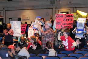 Parents and teachers at the PEP meeting protest the threatened closure of schools