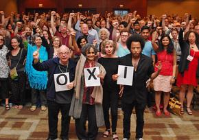 Socialism 2015 participants, including (front, left to right) Wallace Shawn, Arundhati Roy, Deborah Eisenberg and Boots Riley, send a message of solidarity to Greece